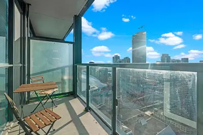 a balcony with a chair and a view of a city at 1-Bedroom & Den condo Bird's Eye View in DT in Toronto