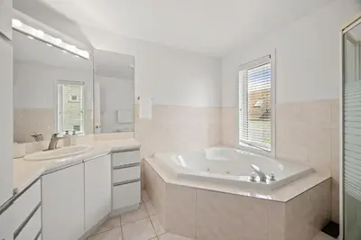 a white bathroom with a tub and a sink at The Wilcox Villa in Mississauga