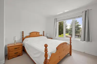 a bedroom with a wooden bed and a window at The Wilcox Villa in Mississauga