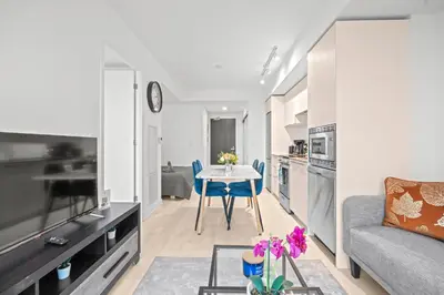 a kitchen and living room with a table and a couch at New Modern 1Bd & Den in Downtown Toronto in Toronto