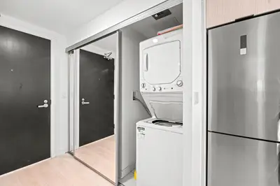 a kitchen with a washer and dryer and a refrigerator at New Modern 1Bd & Den in Downtown Toronto in Toronto