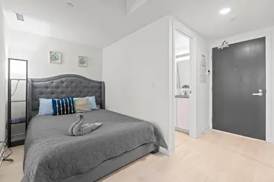 a bedroom with a large bed with a gray blanket at New Modern 1Bd & Den in Downtown Toronto in Toronto