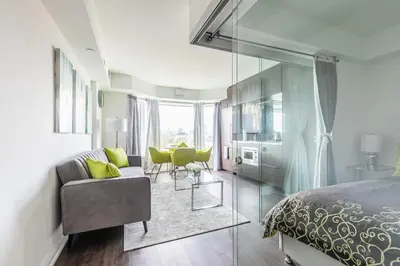 a bedroom with a bed and a table and chairs at Forest 1Bd & DEN in Yorkville 10 Floor in Toronto
