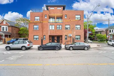 three cars parked in a parking lot in front of a brick building at Mins from Toronto Downtown UFT Exhibition Place in Toronto