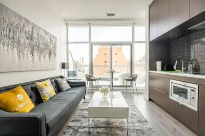a living room with a couch and a table at Gorgeous 1 Bedroom Apt with Balcony in Yorkville in Toronto