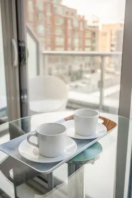 two coffee cups on a glass table in front of a window at Gorgeous 1 Bedroom Apt with Balcony in Yorkville in Toronto