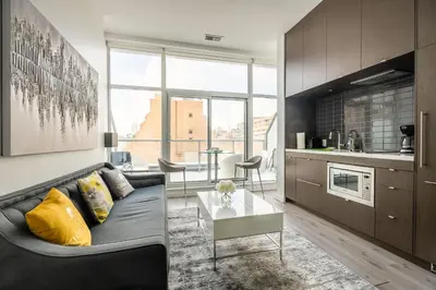 a living room with a couch and a table at Gorgeous 1 Bedroom Apt with Balcony in Yorkville in Toronto
