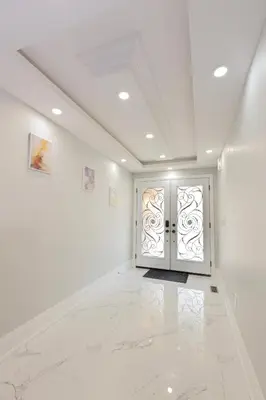 a hallway with white walls and a white door at Greate place with lot of rooms for relaxing in Toronto