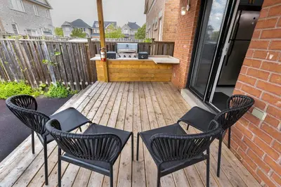 a patio with two chairs and a grill on a deck at Greate place with lot of rooms for relaxing in Toronto