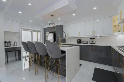 a kitchen with black and white cabinets and bar stools at Greate place with lot of rooms for relaxing in Toronto