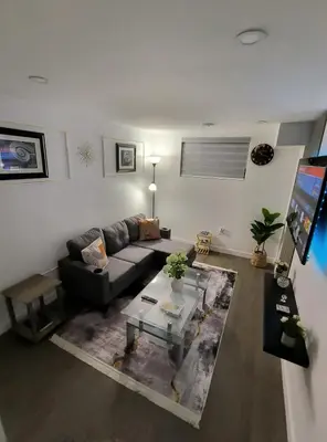 a living room with a couch and a table at ArbyManie's Place Newly Built Basement Apartment in London