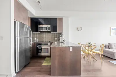 a kitchen with stainless steel appliances and a couch at Cozy 1 Bedroom Dunfield Ave in Toronto