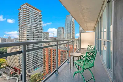 a balcony with a table and chairs and a view of the city at Cozy 1 Bedroom Dunfield Ave in Toronto