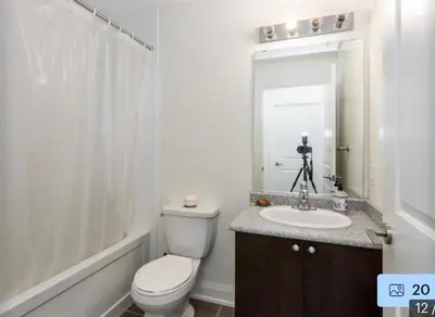 a bathroom with a toilet and a sink and a mirror at Aseesniwas in Brampton