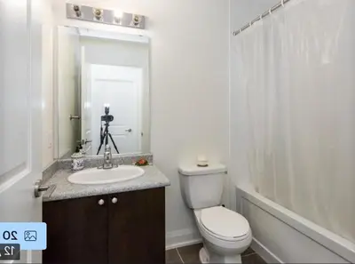 a bathroom with a toilet and a sink and a mirror at Aseesniwas in Brampton