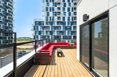 a balcony with a red couch on a building at Modern Townhouse Rooftop Vibes in Oakville