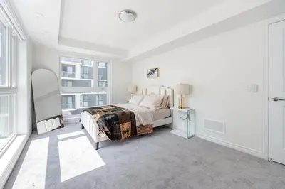 a white bedroom with a bed and a window at Modern Townhouse Rooftop Vibes in Oakville