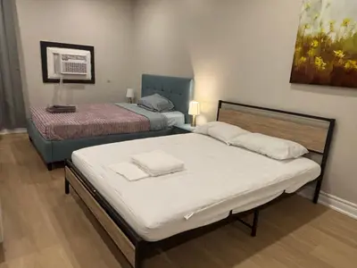 a bedroom with two beds and a painting on the wall at Beautiful apartment DT Toronto in Toronto