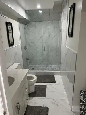 a bathroom with a shower and a toilet and a sink at Cozy 1 Bedroom Apartment in Brampton