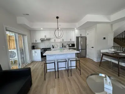 a kitchen with white cabinets and a table and chairs at Downtown Toronto UFT in Toronto