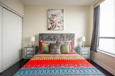 a bedroom with a large bed with a colorful blanket at Modern 1 BR Apartment in North York Free parking in Toronto