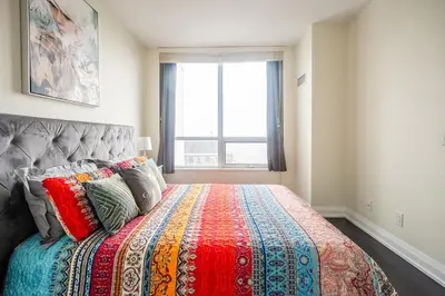 a bedroom with a bed with a colorful blanket at Modern 1 BR Apartment in North York Free parking in Toronto