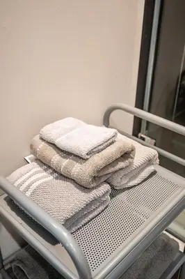 a pile of towels sitting on a towel rack at Modern 1 BR Apartment in North York Free parking in Toronto