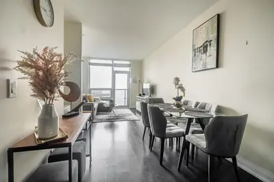 a living room with a dining room table and chairs at Modern 1 BR Apartment in North York Free parking in Toronto
