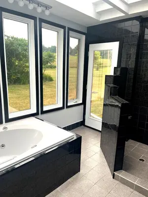 a large bathroom with a tub and windows at Fieldstone & Sky in Frankford