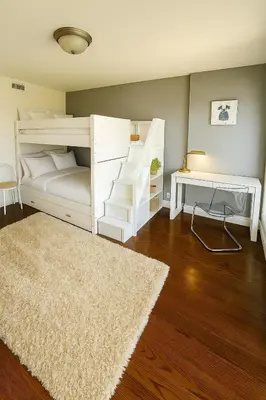 a bedroom with a white bunk bed and a rug at Fieldstone & Sky in Frankford