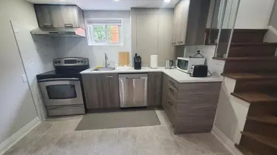 a small kitchen with a sink and a stove at Cozy Basement Stay in Mississauga in Mississauga