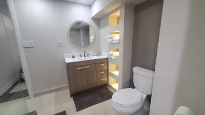 a bathroom with a toilet and a sink and a mirror at Cozy Basement Stay in Mississauga in Mississauga