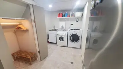 a laundry room with a washing machine and a washer at Cozy Basement Stay in Mississauga in Mississauga