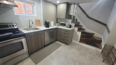 a small kitchen with a sink and a staircase at Cozy Basement Stay in Mississauga in Mississauga