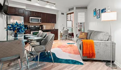 a living room with a couch and a table with chairs at Superior 1Bd & DEN Apartment with Balcony in Toronto