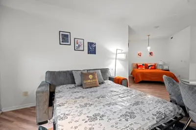 a bedroom with a bed and a bedroom with an orange bed at Superior 1Bd & DEN Apartment with Balcony in Toronto