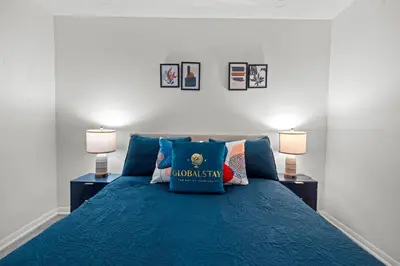 a bedroom with a blue bed with two lamps at Superior 1Bd & DEN Apartment with Balcony in Toronto