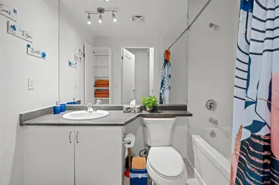 a bathroom with a sink and a toilet and a mirror at Superior 1Bd & DEN Apartment with Balcony in Toronto