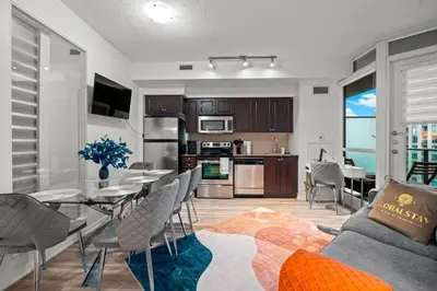 a kitchen and living room with a table and chairs at Superior 1Bd & DEN Apartment with Balcony in Toronto