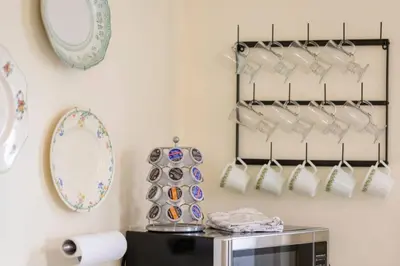 a kitchen with plates and utensils hanging on a wall at Central Picton Apartment, Sleeps 8; The Iron Horse in Picton
