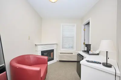 a living room with a red chair and a fireplace at Nine Vines Hotel in Niagara on the Lake