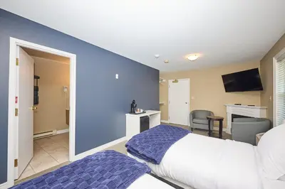 a bedroom with a white bed and a blue wall at Nine Vines Hotel in Niagara on the Lake