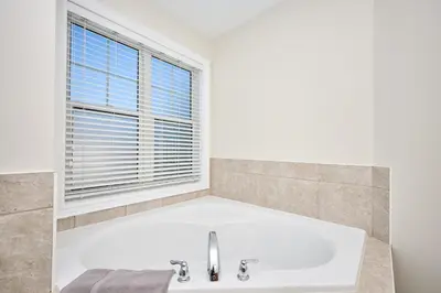 a white bath tub in a bathroom with a window at Nine Vines Hotel in Niagara on the Lake