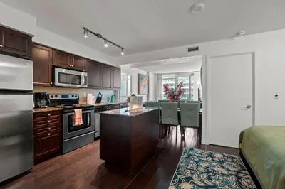 a kitchen and dining room with a table and chairs at Autumnaly Whisper 2 BR & DEN in the Heart of the City in Toronto