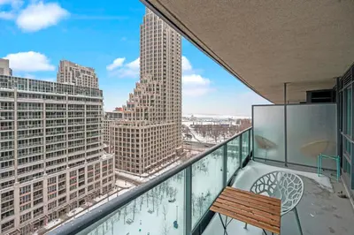a balcony with a bench and a view of a city at Autumnaly Whisper 2 BR & DEN in the Heart of the City in Toronto