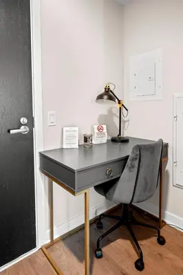 a desk with a lamp and a chair next to a door at Bright 1BD & Den in Downtown Toronto in Toronto