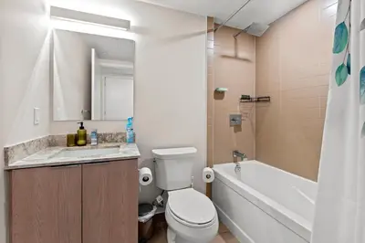 a bathroom with a toilet and a sink and a tub at Bright 1BD & Den in Downtown Toronto in Toronto