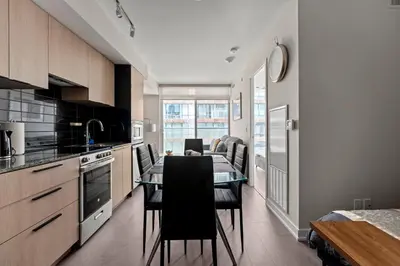 a kitchen with a table and chairs in a room at Bright 1BD & Den in Downtown Toronto in Toronto