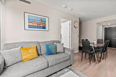 a living room with a couch and a table with chairs at Bright 1BD & Den in Downtown Toronto in Toronto