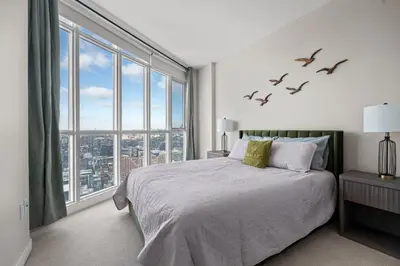 a bedroom with a bed and a large window at High Floor 1 Bedroom Condo Iceboat Terrace Downtown Toronto in Toronto